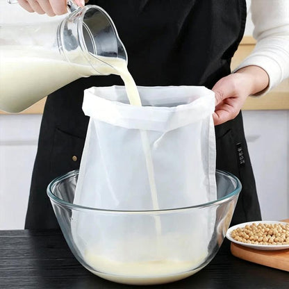 White soy milk filter bag held over a glass bowl, ready to strain liquid.
