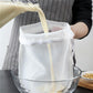 White reusable filter bag with open top set into a glass bowl for straining.