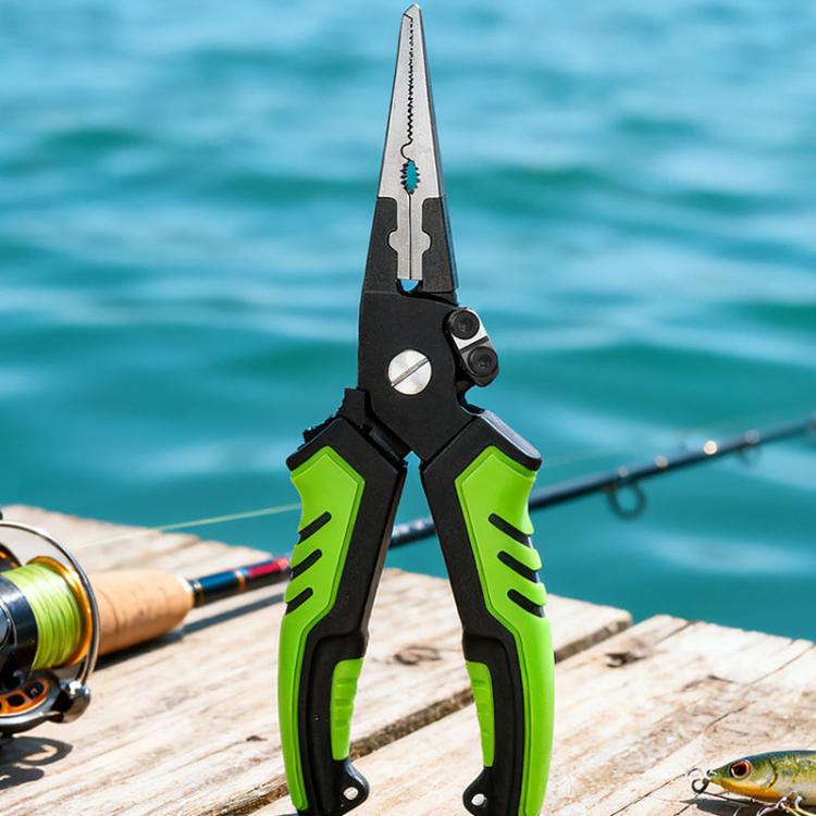 Green fishing line cutting shears with hook remover, shown outdoors on a dock.