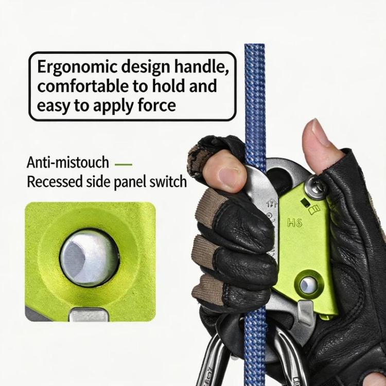 Green and gray rope ascender held in a black glove on a climbing line