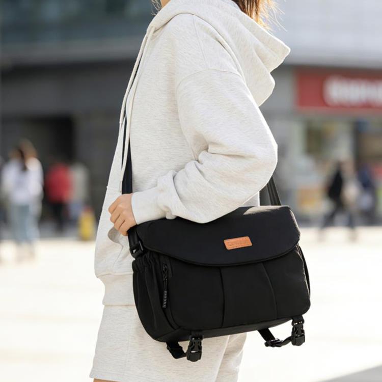 Black DSLR camera shoulder bag with flap front and adjustable strap