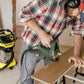 Dust extraction hose attached to an angle grinder during woodworking, black flexible tubing