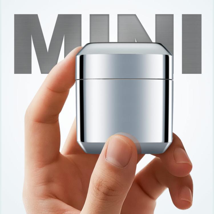 Mini electric shaver in small metal housing held in hand