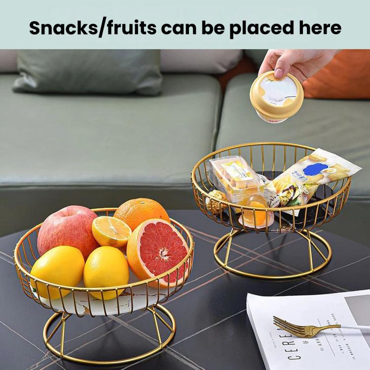 Round wrought iron fruit tray set with gold stands holding fruit and snack packs on a table.