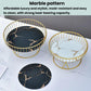 Pair of round wrought iron fruit trays with gold rims and black-and-white marble pattern inserts.