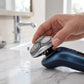 Hand holding rotary shaver replacement head over wet sink