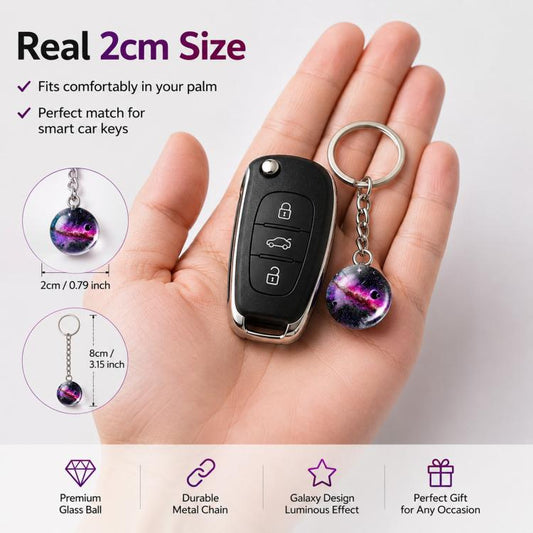 Galaxy crystal ball keychain pendant on chain keyring held in a hand.