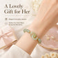 Green jade-style beaded bracelet on wrist with interlocking double loop and gold accents