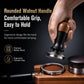 Coffee tamper held in hand with walnut wood handle, black body, and stainless tamp base