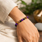 Wrist-worn crystal beaded bracelet with purple and tiger-eye beads on dark beads