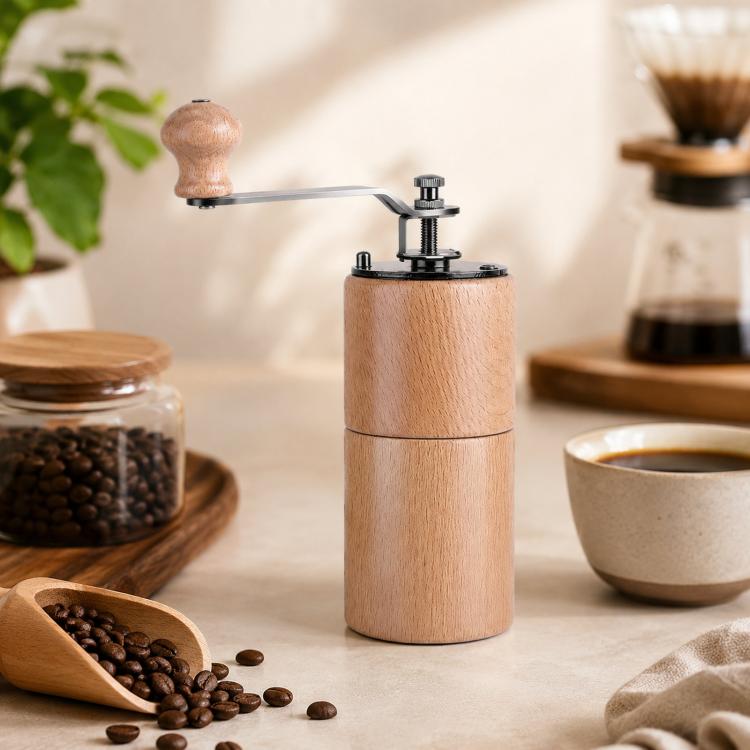 Light wood hand-cranked coffee grinder standing on counter with metal grinding mechanism