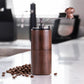 Dark wood hand-cranked coffee grinder with metal crank and bean hopper funnel