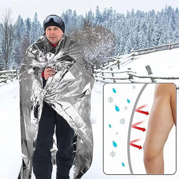Silver emergency thermal blanket worn outdoors, reflective insulation wrap