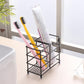 Black wrought iron toothbrush storage rack holding toothbrushes and a toothpaste tube