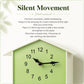 House-shaped wall clock face in light green with black hands and bird chime window