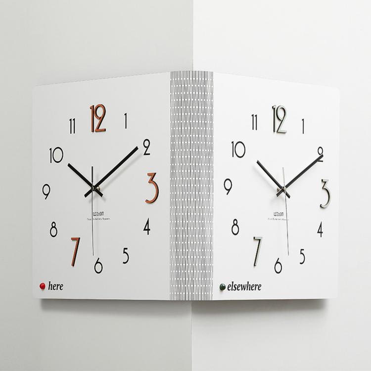 White dual-sided corner wall clock with black hands and small here/elsewhere markers