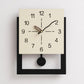 Cream white wall clock with minimalist dial, black hands, and round black pull ring