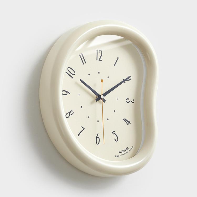 Cream oval wall clock with white face, minimalist hands and number markers