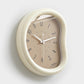 Light beige oval wall clock with light face, minimalist hands and number markers
