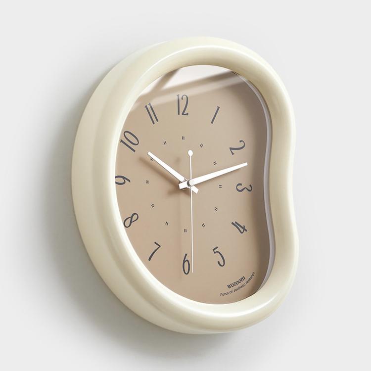 Light beige oval wall clock with light face, minimalist hands and number markers