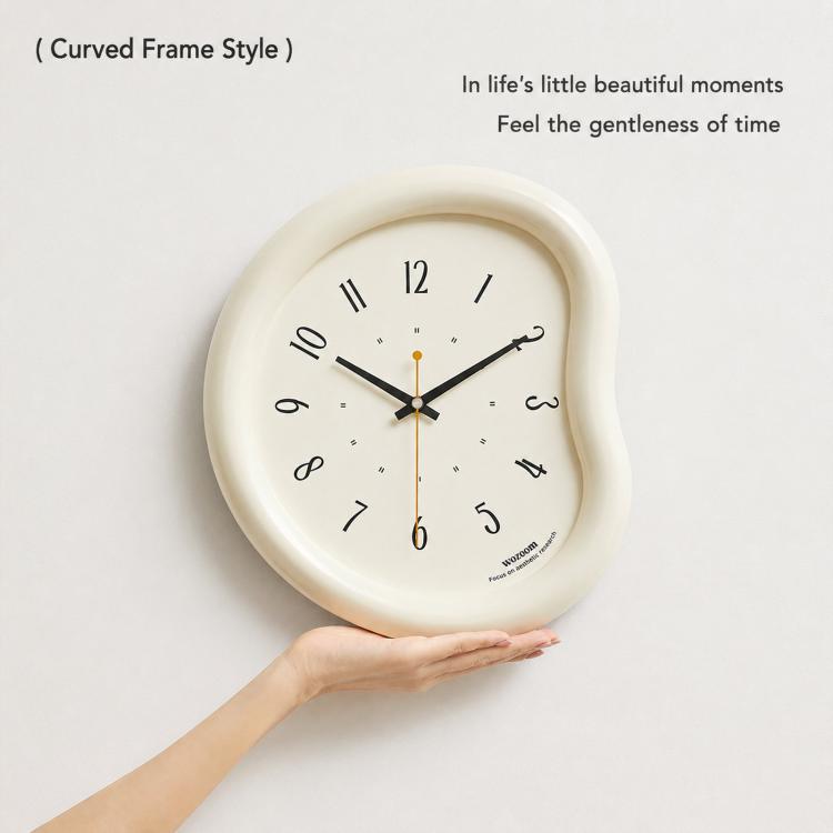 Beige curved-frame wall clock being held up, light face with number markers