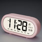 Pink digital alarm clock with large time, date, and temperature display icons