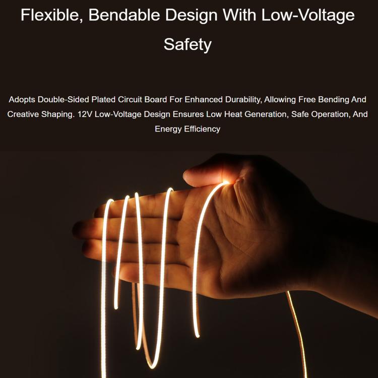 Flexible warm white LED strip glowing while bent in a hand test