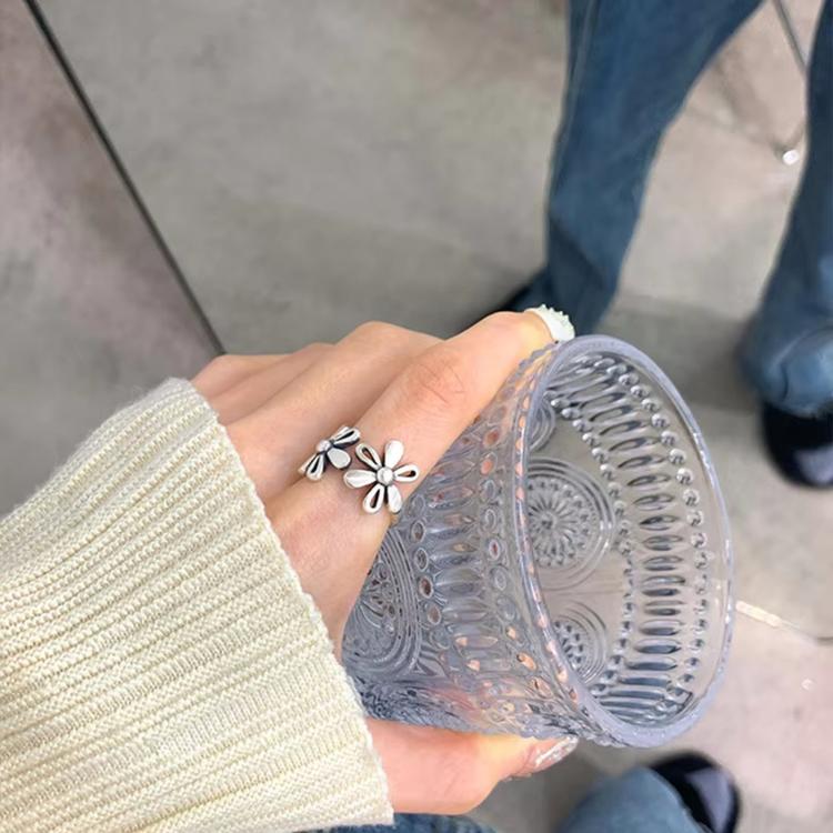 Sterling silver daisy flower open ring on hand, close-up view