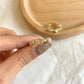 Adjustable heart ring showing pink enamel-like stones and gold-tone open band