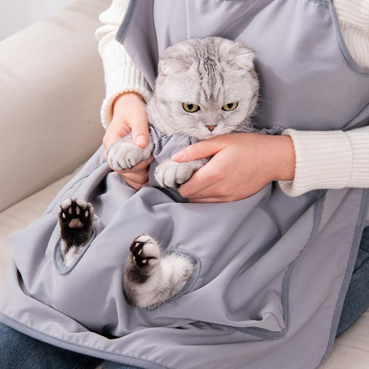 Gray cat grooming apron with front pouch and paw openings, worn over sleeves