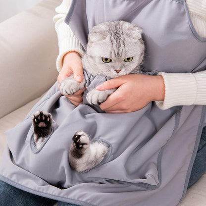 Gray cat grooming apron with front pouch and paw openings, worn over sleeves