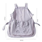Light gray cat grooming apron with wide front pouch and paw-shaped cutouts, flat lay