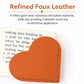 Orange heart-shaped bookmark corner clip on an open book, stitched faux leather