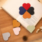 Mixed heart-shaped bookmark corner clips on an open book, faux leather corner protectors