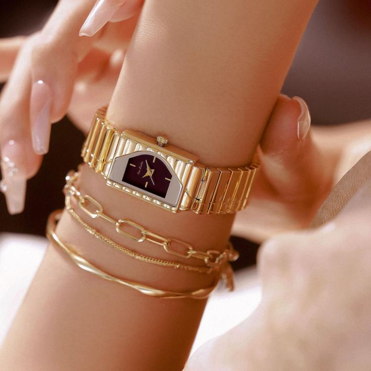 Gold womens vintage quartz wristwatch with dark geometric dial and metal bracelet on wrist