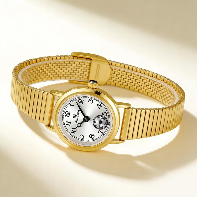 Gold-tone wristwatch with small round face, textured expansion band, and seconds subdial