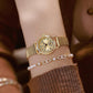 Gold-tone small round watch on wrist with ribbed expansion band and seconds subdial