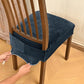Dark blue-gray velvet stretch chair seat cover with buckle straps, being fitted on chair