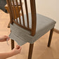 Matcha green textured dining chair seat cover being fastened with elastic and buckles
