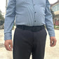 Black nylon web belt with automatic buckle worn at the waist with dark trousers