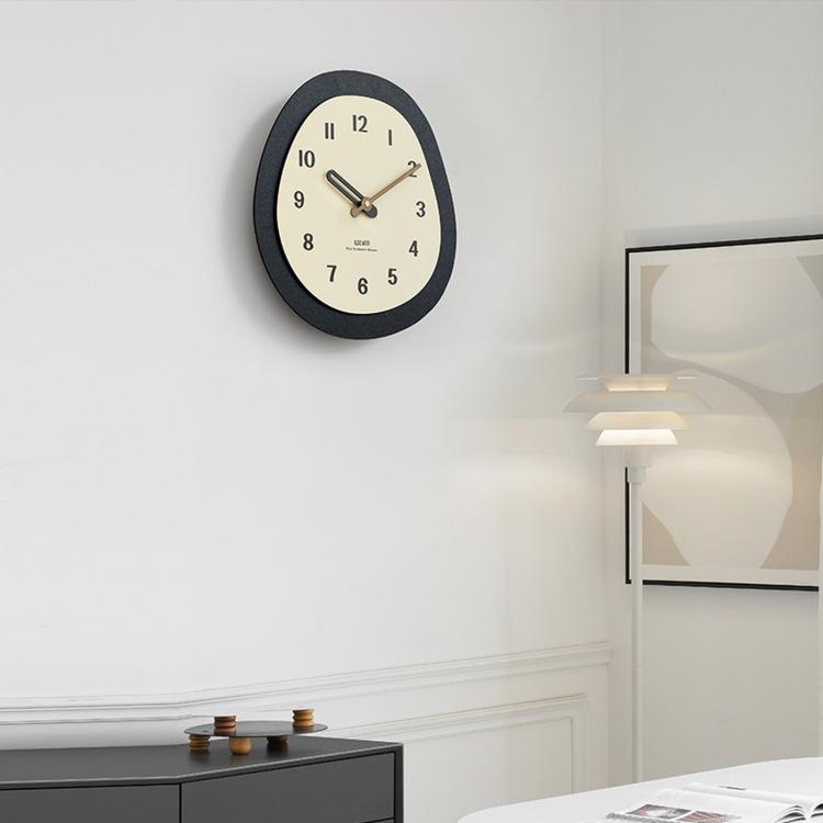 Modern oval wall clock with dark frame, cream face, and walnut wood hands
