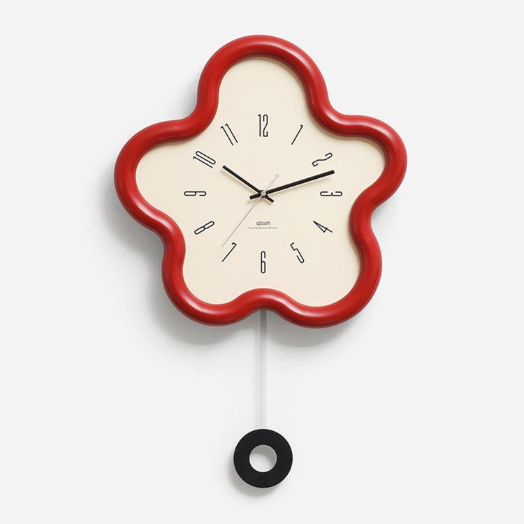 Flower-shaped wall clock with red frame, cream face, black hands; hanging cord visible.