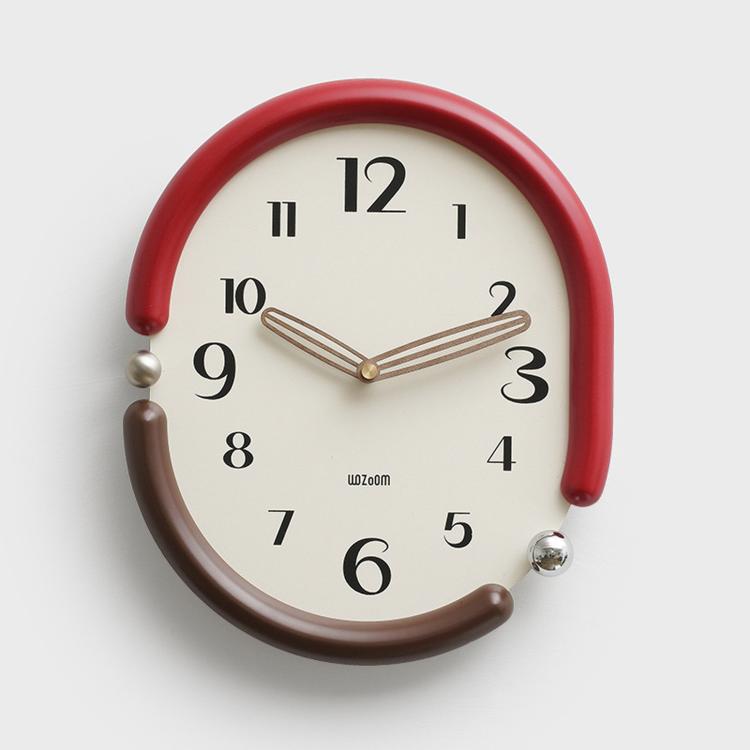 Retro oval wall clock with red frame, cream dial, striped gold hands and black hour marks.