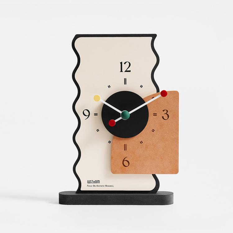 Geometric desk clock with cream back, black dial, orange panel, and colored hour markers