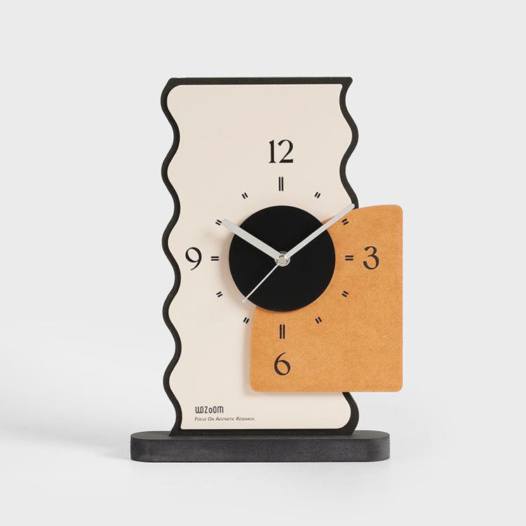 Geometric desk clock with cream back, black dial, orange panel, and slender line hands
