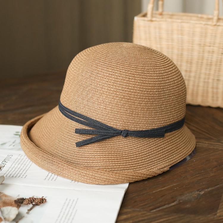 Beige straw cloche sun hat with navy ribbon bow on dark band, foldable style