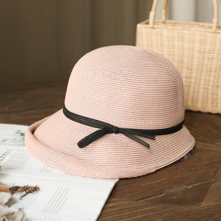 Light pink straw cloche sun hat with black ribbon bow on dark band, foldable style