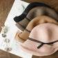 Stack of foldable straw cloche hats with ribbon bows: pink, beige, and black