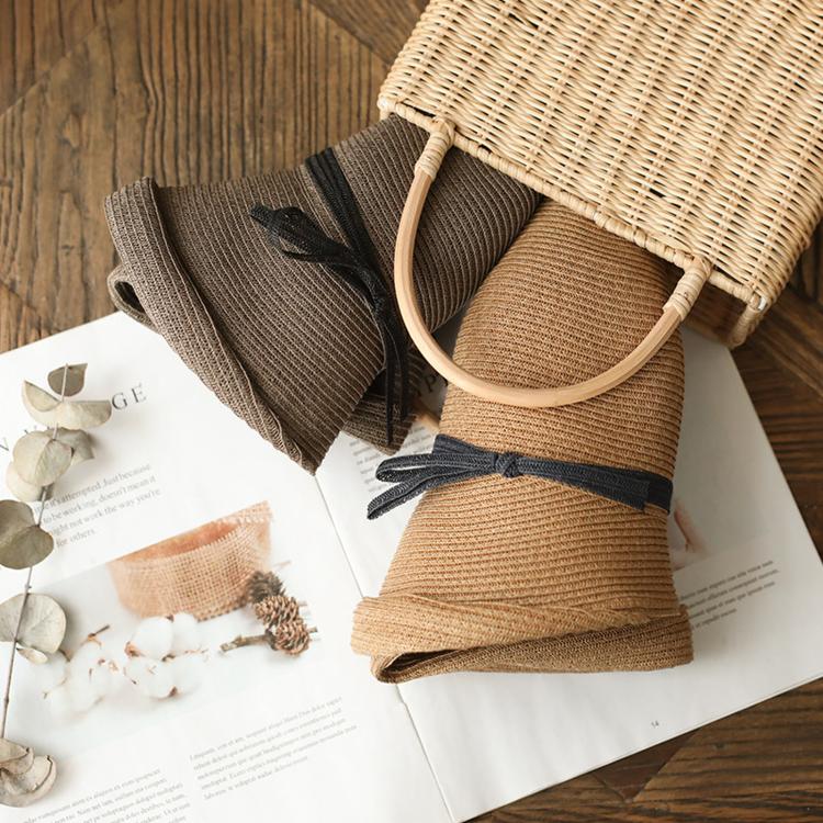 Foldable straw cloche hats with ribbon bows in dark and tan, shown side by side