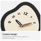 Irregular wall clock face with black frame, cream dial, and walnut plus black hands